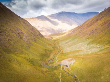 Bulutlu gökyüzü ve Kafkas dağlarının arka planıyla Juta Vadisi 'ne dramatik hava manzarası