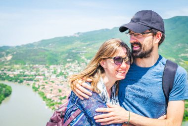 Erkek ve dişi mutlu bir şekilde oturur ve birlikte güzel manzaralı bir yere seyahat ederler.