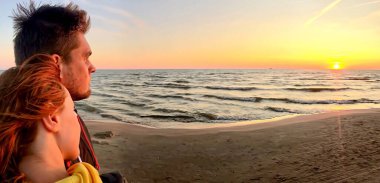 Baltık Denizi ufkunda gün batımını izleyen çiftin yakın görüntüsü..