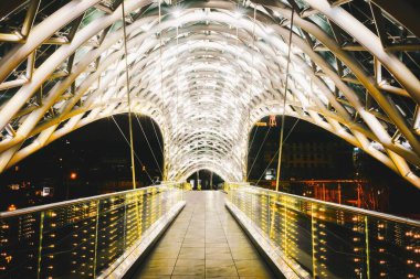 Tiflis, Gürcistan - 15 Şubat 2021. Sokağa çıkma yasağı olan insanlar olmadan aydınlatılmış barış köprüsü