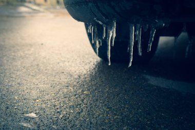 Buzlu yolda lastikleri olan buz saçağı araba bumber 'ını kapatın. Kaygan yol koşulları kavramı