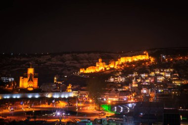 Karlı dağları ve aydınlık şehirleriyle Panoramik gece görüşü eski Tiflis