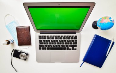 Yaz tatili arka plan konsepti için dizüstü bilgisayarın beyaz ahşap masada görüntüsünü oluşturun. Dizüstü bilgisayarın, kameranın, kopya alanı arka planına sahip küresel pandemik aksesuarların düz görünümü