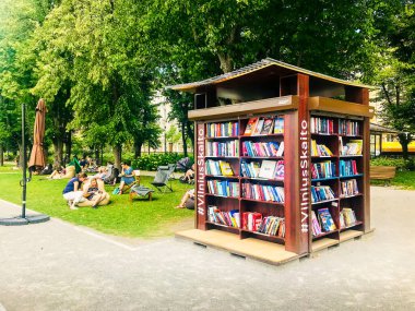 Vilnius, Litvanya - 15 Haziran 2018: Vilniusskaito kamu kitap rafı park tabiatında okumak için durdu.