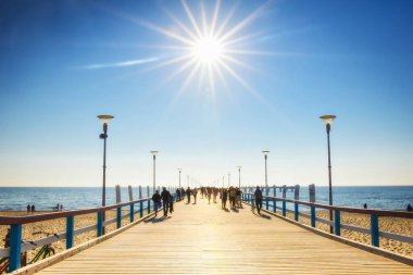 Palanga, Litvanya - 6 Haziran 2021: Güneşli yaz günlerinde sıcak havada yürüyen turistlerle birlikte Palanga iskelesi. Litvanya tatil beldesi.