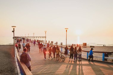 Palanga, Litvanya - 6 Haziran 2021: Güneşli yaz günlerinde sıcak havada yürüyen turistlerle birlikte Palanga iskelesi. Litvanya tatil beldesi.