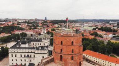 Ünlü Gediminas şatosu bulutlu bir günde bayraklarla kaplıdır ve turistler panoramik manzaranın tadını çıkarırlar. Vilnius gezisi konsepti kopyalama yapıştırıcısı.