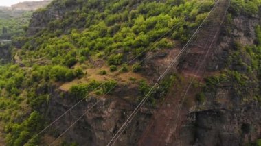 Chiatura 'daki madencilik alanında, yolun yukarısındaki boş kovada, havadan izlenen yol manzaralı. Taşıma konteynırı. Endüstri vinçleri ve kablolu tren yolu üzerinde gün batımı. Ulaştırma ve Madencilik Endüstrisi