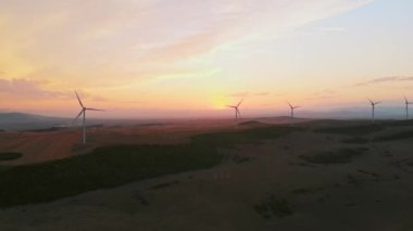 Hava statik görüntüsü. Beş rüzgar türbini yeşil alanda duruyor. Gökyüzü manzarası çok güzel. Yenilenebilir enerji konseptini kopyala