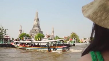 Bangkok, Tayland - 15 Ocak 2024: Bangkok, Tayland 'ın Bangkok Yai bölgesindeki Wat Arun -Budist tapınağına bakan genç güzel kadın turist. Thonburi, Chao Phraya Nehri 'nin batı kıyısında.
