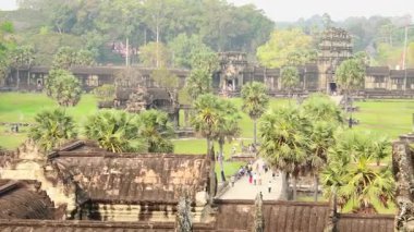 Siem Reap, Kamboçya - 25 Şubat 2023: Tropikal orman ve antik taş mimarisi ile Angkor Wat Tapınağı. UNESCO Dünya Mirası Alanı, arkeolojik dönüm noktası. Khmer İmparatorluğu mirası.
