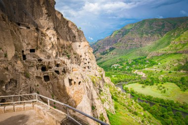 Antik Vardzia mağara manastırı Gürcistan 'ın güneyindeki kayalıklara oyulmuş yemyeşil vadi ve Mtkvari Nehri' ne bakan bahar mevsimi boyunca.