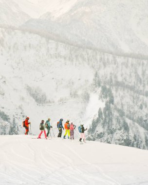 Karlı Tetnuldi yamacında kayak yapan bir grup kayakçı Svaneti Georgia kış sporları dağ pudrası eğlence günü macera turizmi Kafkaslar kayak tatil yeri orman manzarası