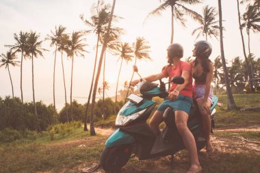 Romantik beyaz çift kiralık scooter 'da oturur Sri Lanka' da gün batımını seyrederler. Özgürlük ve macera. Yolculuk. Asya 'da birlikteliği ve tatilleri kucaklamak. Scooter konsepti kiralanıyor