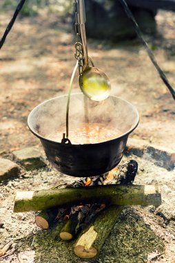 Tencerede ateşte yemek pişirmek. Açık ateşte goulash hazırlıyorum. Vahşi takip, ilkbaharda yürüyüş. Gece boyunca kal.