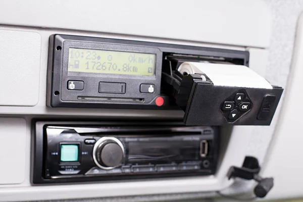 Цифровой тахограф с открытым принтером и видимым рулоном бумаги. Автомобильное радио и телефонный микрофон. Замена бумаги в цифровом тахографе грузовика. — стоковое фото