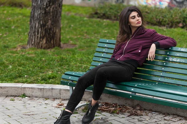 Hermosa mujer retrato sentado en el banco en el parque —  Fotos de Stock