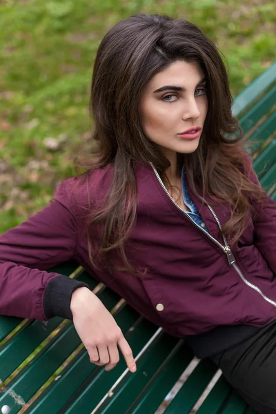 Hermosa mujer retrato sentado en el banco y mirando a la cámara —  Fotos de Stock