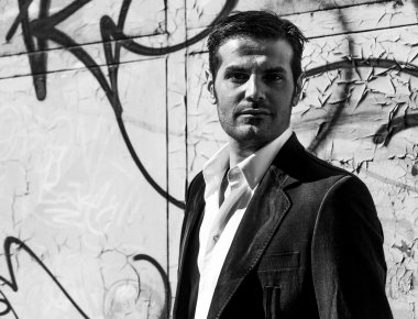 Yakışıklı adam portre kentin grafiti yakınındaki tek renkli duvar
