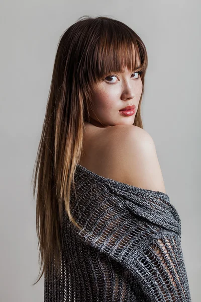 Beautiful girl portrait wearing grey sweater and looking back — Stock Photo, Image