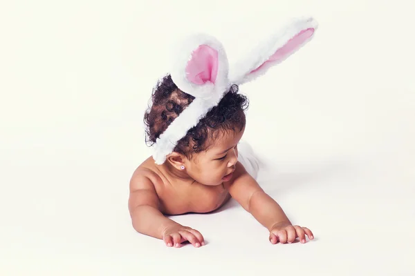 Cute baby girl wearing bunny ears and looking aside — Stock Photo, Image
