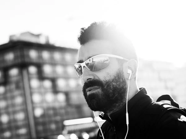 Retrato de deportista guapo en la ciudad con gafas de sol monótonas — Foto de Stock