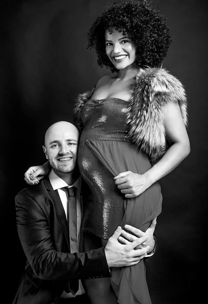 Glücklicher Vater umarmt schwangere Mutter und lächelt schwarz-weiß — Stockfoto