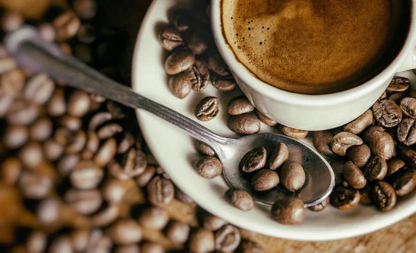 Taza de café con granos de café y bokeh —  Fotos de Stock