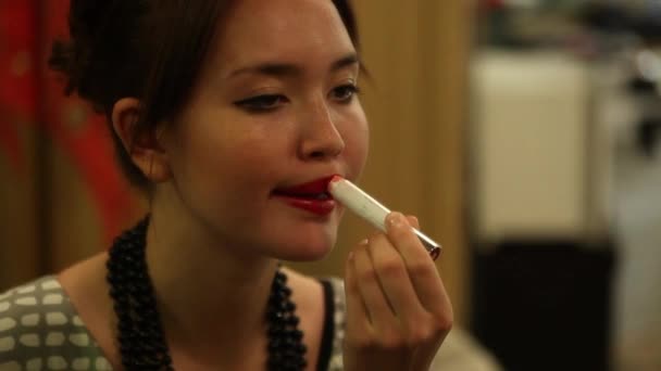 Pretty girl applying red lipstick in front of the mirror — Stock Video