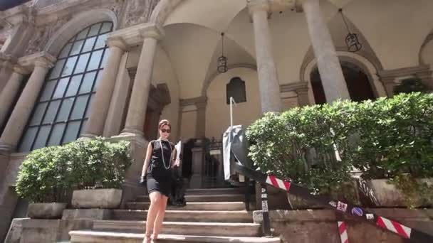 Красивая и элегантная женщина спускается по служебной лестнице — стоковое видео