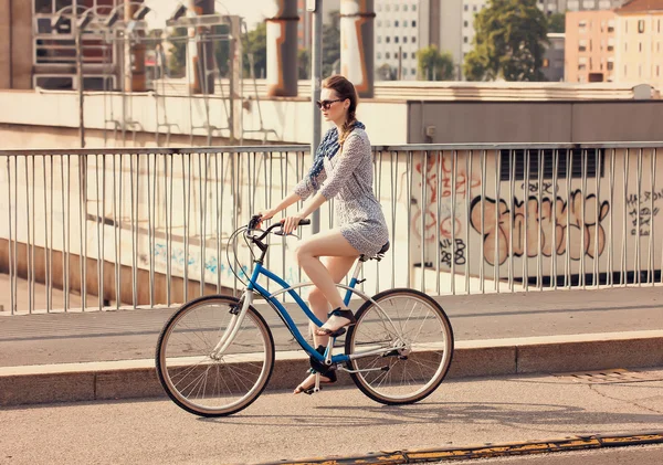 Krásná žena na koni kolo v městě v létě — Stock fotografie