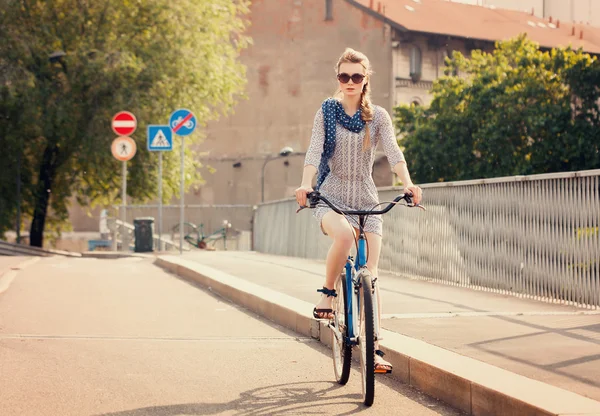 Pretty woman riding bike in the city in Summer