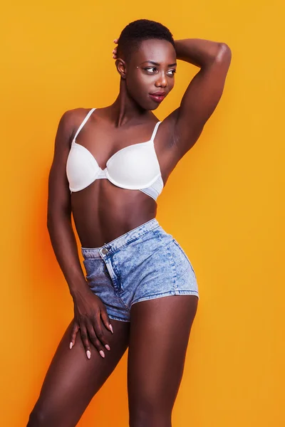 Beautiful african girl wearing jeans shorts and bra while posing — Stock Photo, Image