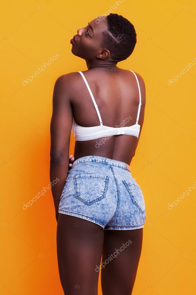 Pretty african girl back portrait wearing jeans shorts and bra