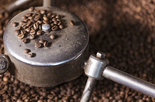 Granos de café de cerca en el tostador de café — Foto de Stock