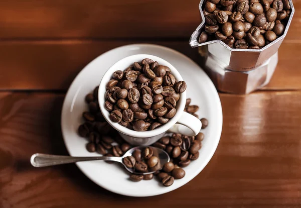 Coffee cup and percolator full of coffee beans — Stock Photo, Image