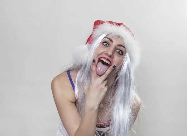 Girl wearing Santa Claus hat and making funny gesture — Stock Photo, Image