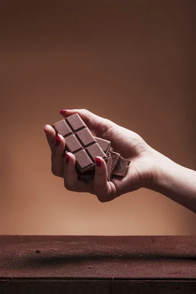 Weibliche Hand hält Schokoladenblock — Stockfoto