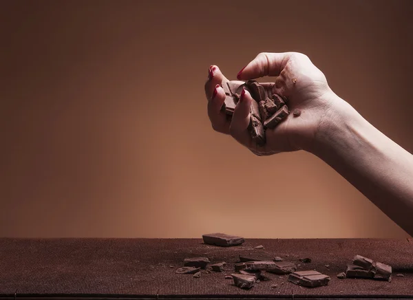 Hand letting chocolate pieces fall — Stock Photo, Image