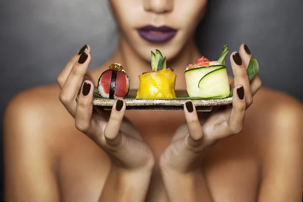 Hermosa modelo sosteniendo comida tradicional japonesa — Foto de Stock