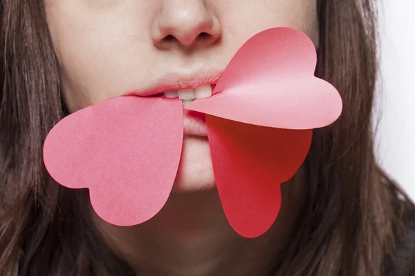 Angry girl biting paper hearts — Stock Photo, Image