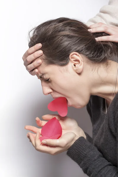Girl sick of love vomiting red hearts — Stock Photo, Image
