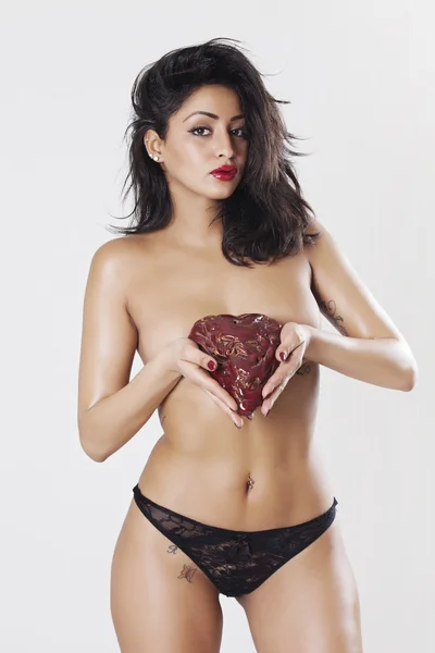 Hermosa mujer sosteniendo piedra del corazón y usando ropa interior — Foto de Stock