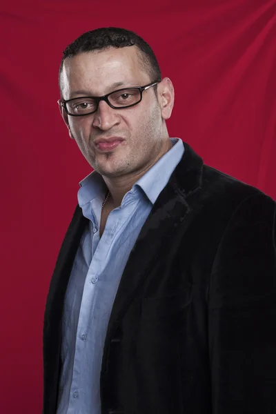 Retrato de homem franzino usando óculos no fundo vermelho — Fotografia de Stock