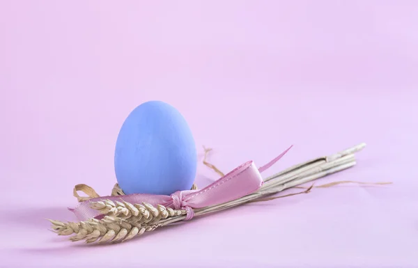 Пасхальная композиция с голубым окрашенным яйцом и снопом пшеницы — стоковое фото