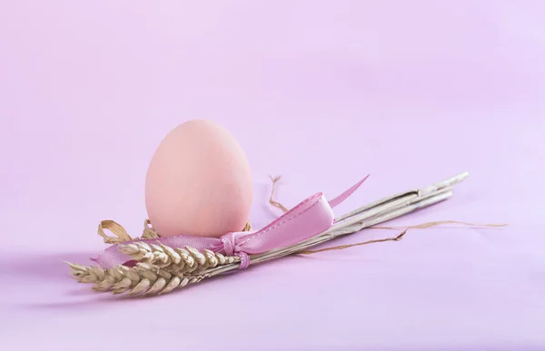 Osterkomposition mit orange bemaltem Ei und Weizengarbe — Stockfoto