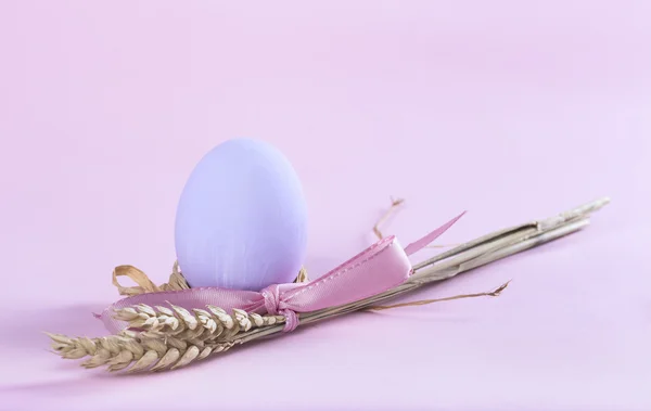Pasen samenstelling met paarse geschilderde ei en schoof van tarwe — Stockfoto