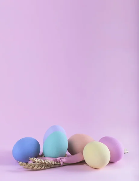 Composición colorida de huevos de Pascua con gavilla de trigo vertical ca — Foto de Stock