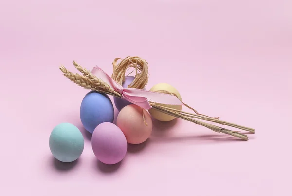 Composición de Pascua de huevos coloridos y gavilla de trigo — Foto de Stock