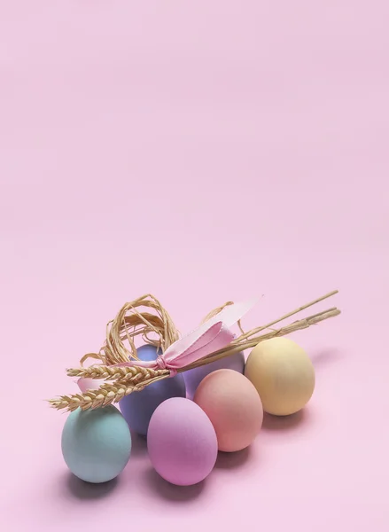 Composición colorida de huevos de Pascua y gavilla de coche de saludo de trigo — Foto de Stock